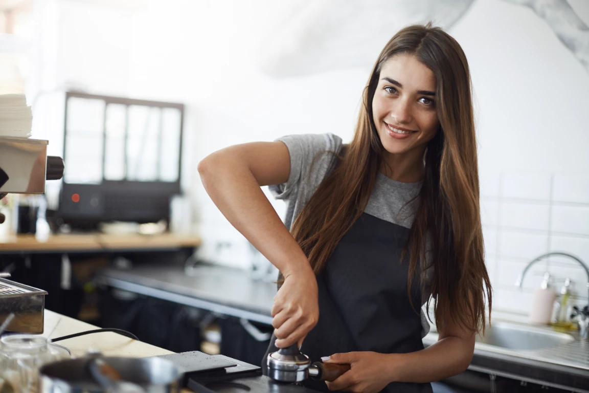 Chica trabajando en una cafetería mientras considera contratar un PPR para su retiro.